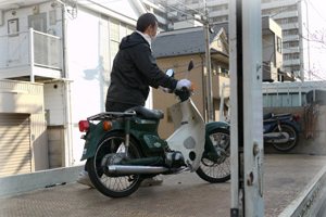 動かないバイクをトラックへ積み込む作業